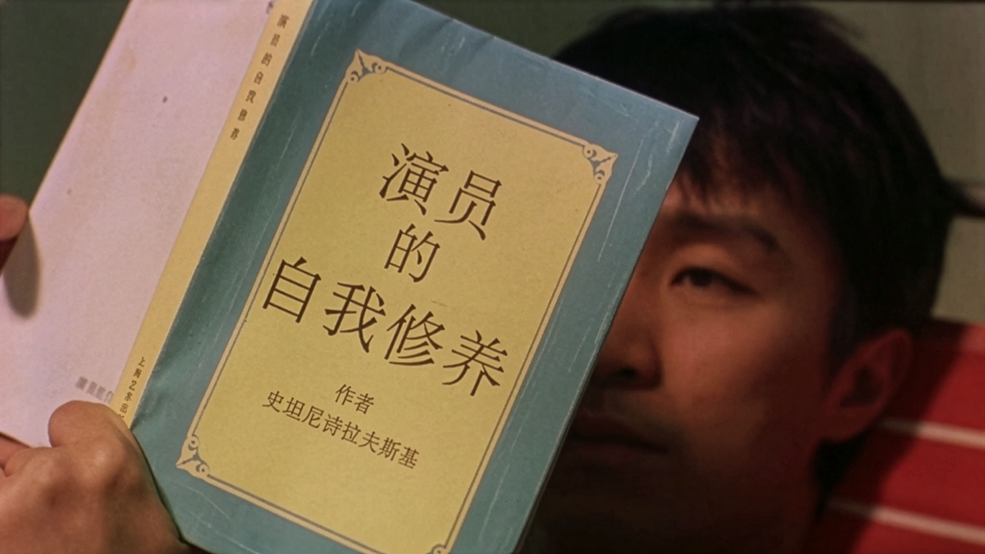 Wan Tin-Sau (Stephen Chow) holding his prized copy of 'An Actor Prepares' by Stanislavski, the book that became a cultural icon after this film.